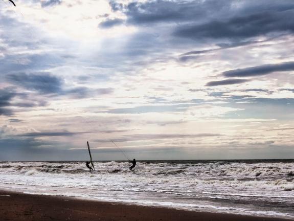 Kiter und Windsurfer begegnen sich auf dem Wasser